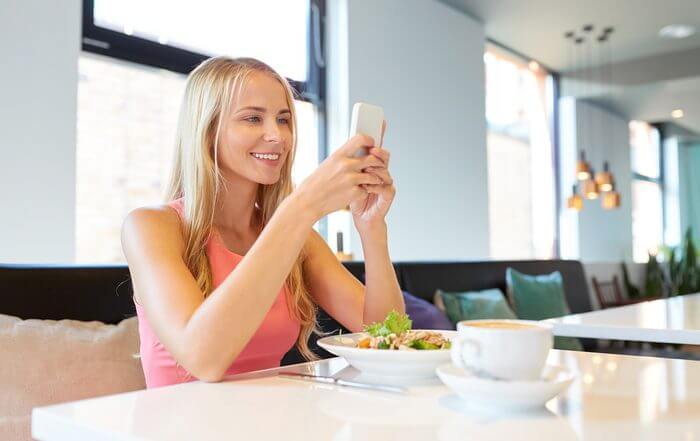 Woman photographing her meal with a smartphone for diet tracking